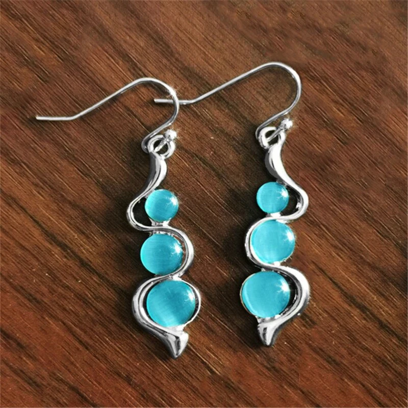 Rangée Entrelacée | Boucles d'oreilles argentées avec trois pierres turquoise – Vue 01