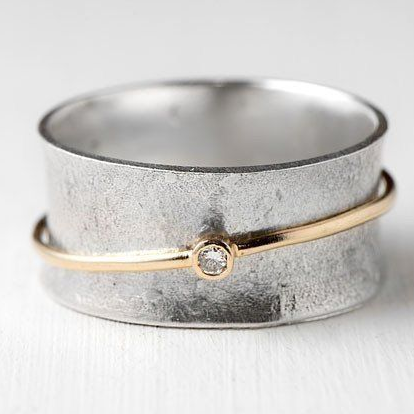 Bague argentée avec fine ligne dorée et petite pierre claire