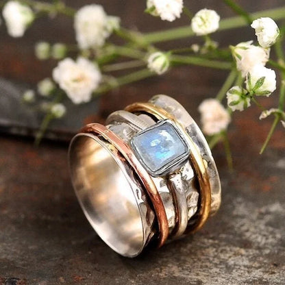 Bague tournante argentée avec bandes dorées et pierre claire