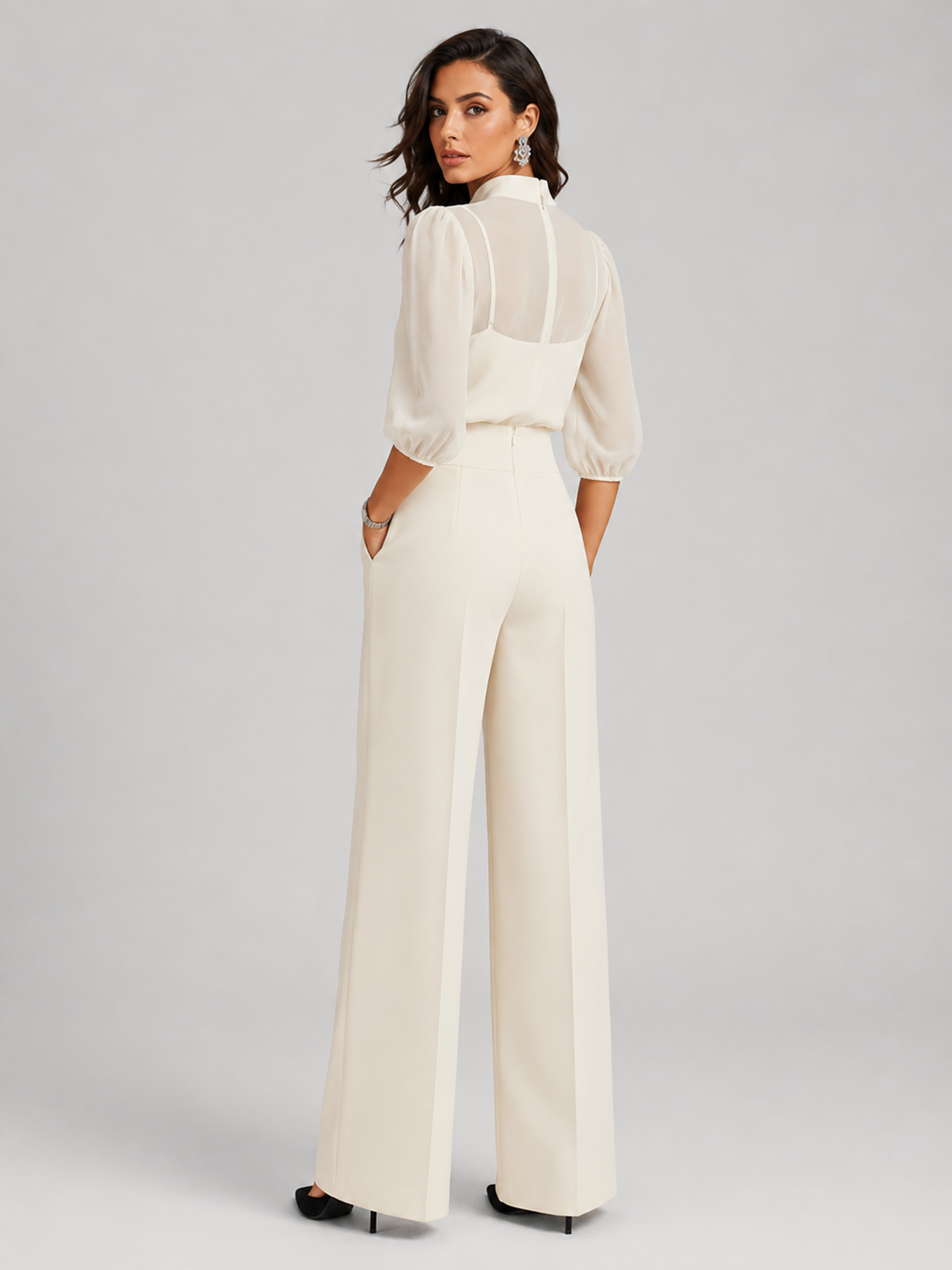 Femme portant un ensemble trois pièces avec blouse transparente et pantalon large, coloris blanc