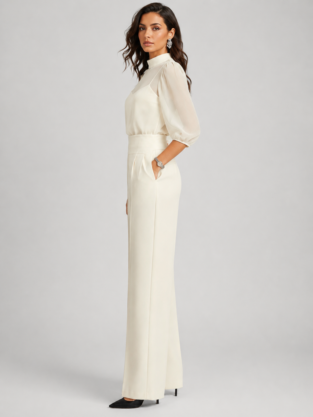 Femme portant un ensemble trois pièces avec blouse transparente et pantalon large, coloris blanc