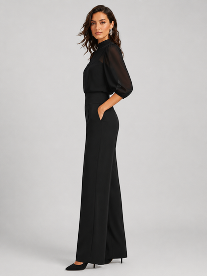 Femme portant un ensemble trois pièces avec blouse transparente et pantalon large, coloris noir