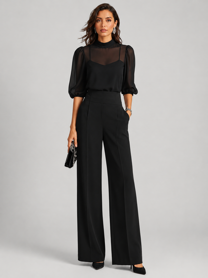 Femme portant un ensemble trois pièces avec blouse transparente et pantalon large, coloris noir