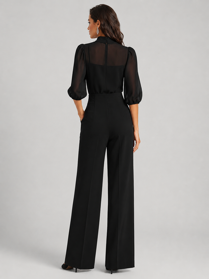 Femme portant un ensemble trois pièces avec blouse transparente et pantalon large, coloris noir
