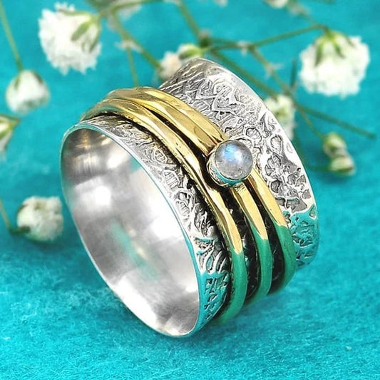 Bague tournante large argentée à motif floral et pierre claire