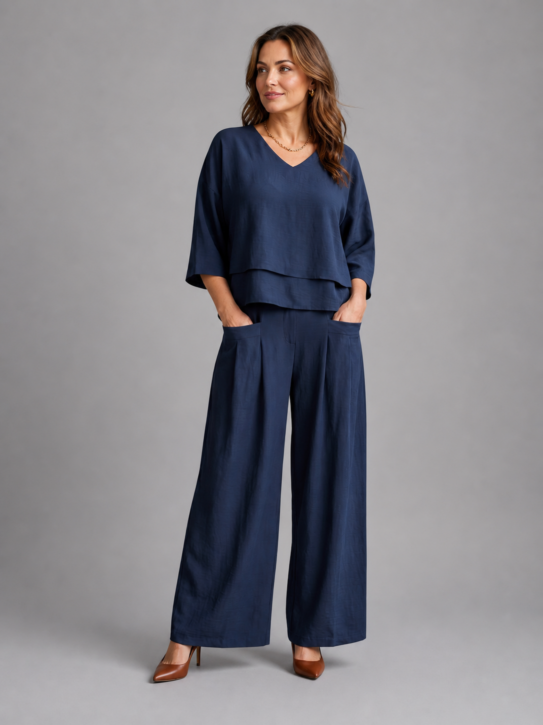 Femme portant un ensemble deux pièces avec haut superposé et pantalon à jambes larges, coloris bleu marine