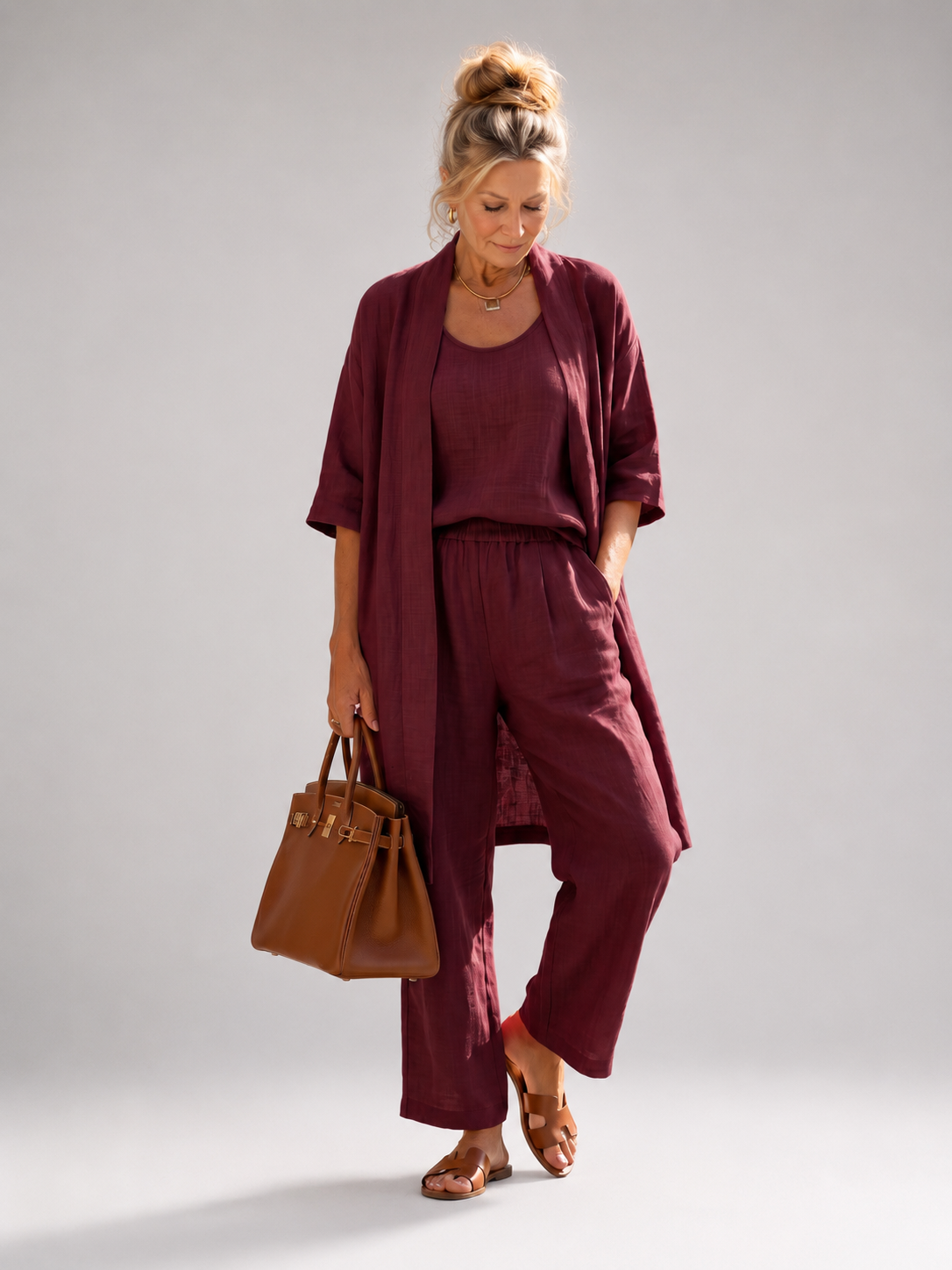 Femme portant un ensemble trois pièces avec haut, pantalon large et pièce ouverte assortie, coloris rouge