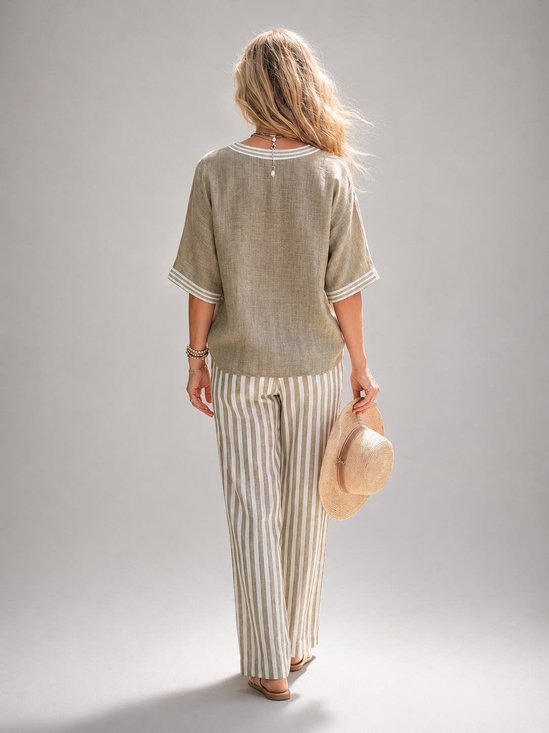 Femme portant un ensemble deux pièces avec tunique col V et pantalon large à rayures, coloris vert sauge