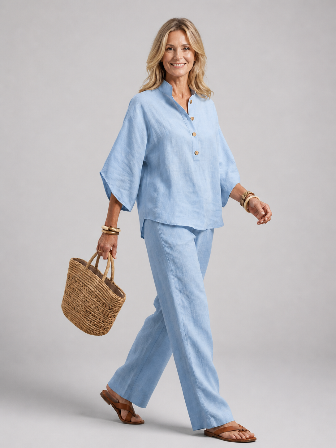 Femme portant un ensemble deux pièces avec tunique boutonnée et pantalon droit, coloris bleu ciel