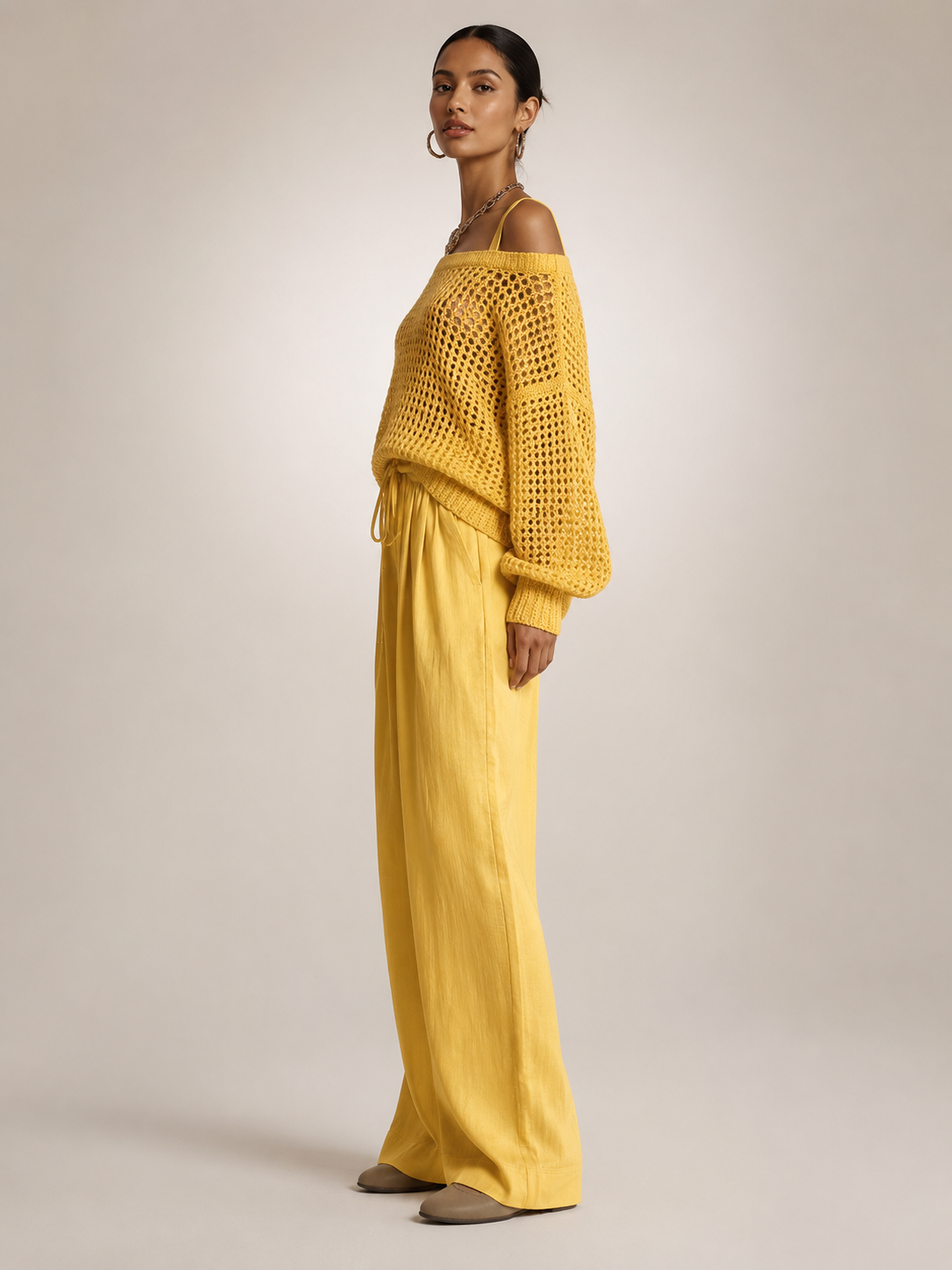 Femme portant un ensemble deux pièces avec haut en maille épaules dénudées et pantalon large, coloris jaune