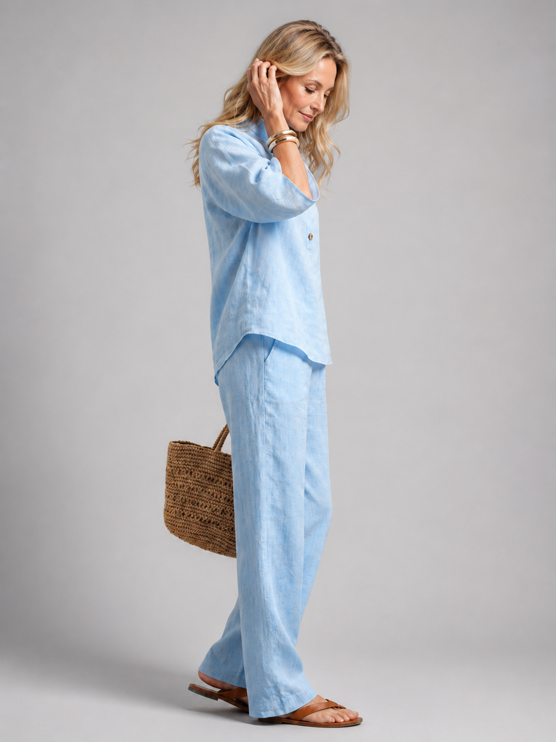Femme portant un ensemble deux pièces avec tunique boutonnée et pantalon droit, coloris bleu ciel