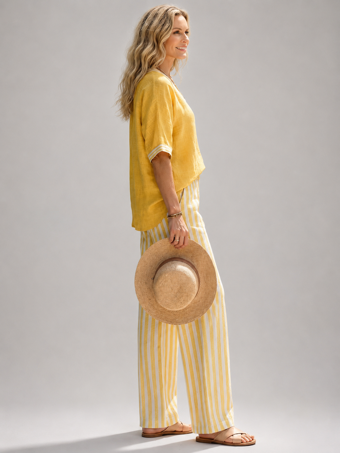 Femme portant un ensemble deux pièces avec tunique col V et pantalon large à rayures, coloris jaune
