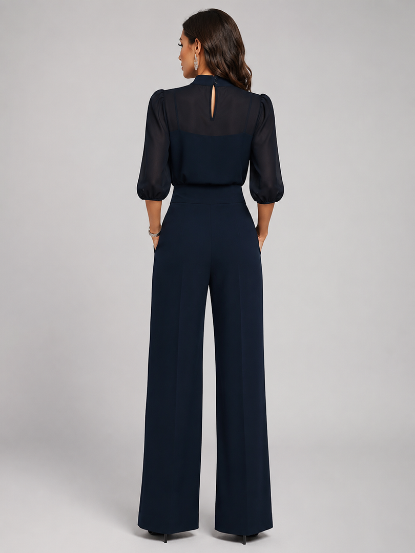 Femme portant un ensemble trois pièces avec blouse transparente et pantalon large, coloris bleu marine