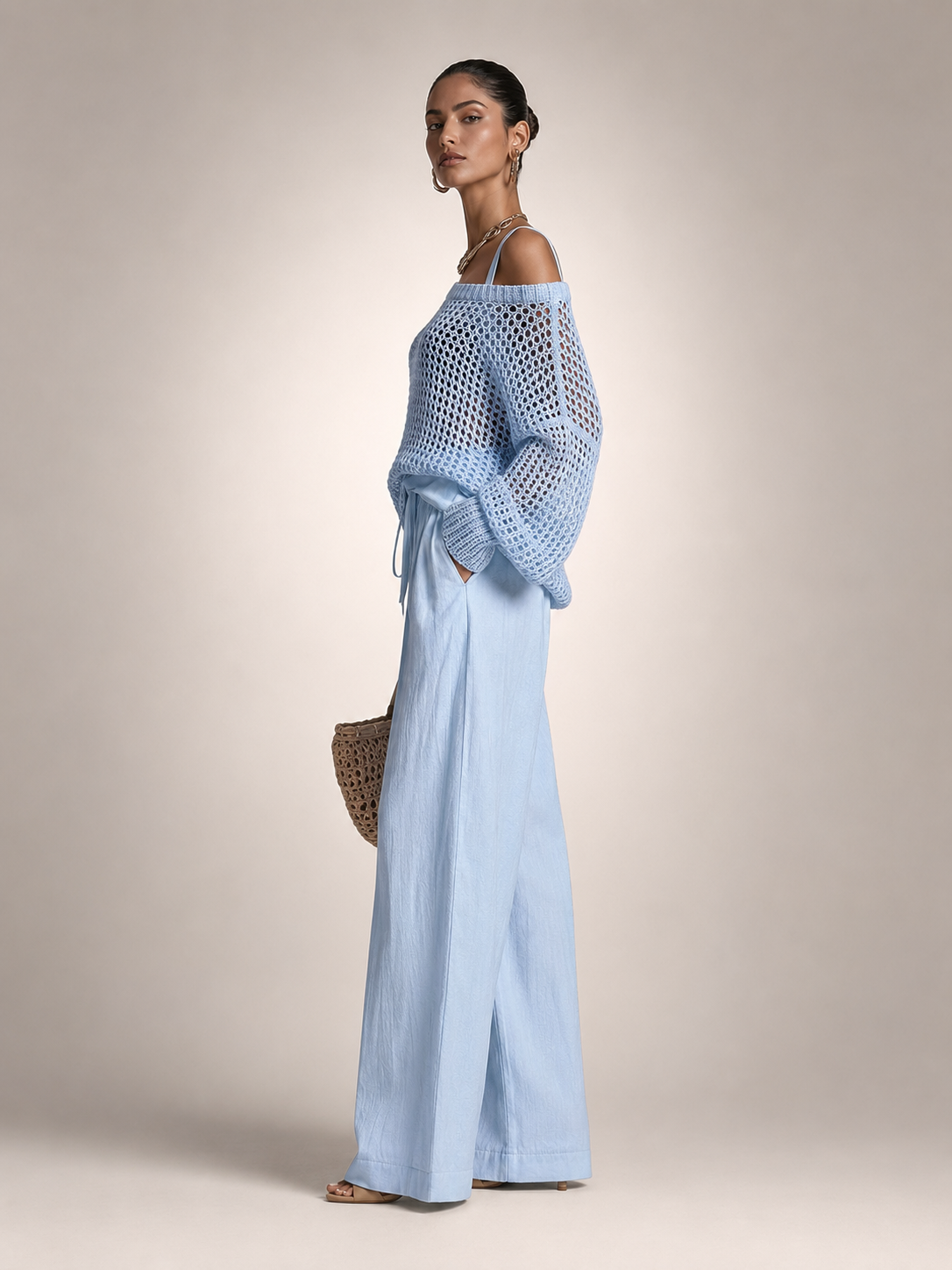 Femme portant un ensemble deux pièces avec haut en maille épaules dénudées et pantalon large, coloris bleu clair