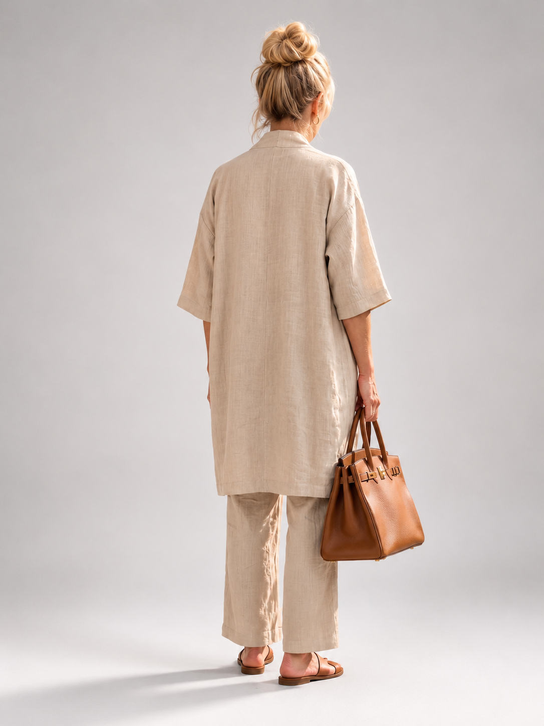 Femme portant un ensemble trois pièces avec haut, pantalon large et pièce ouverte assortie, coloris beige
