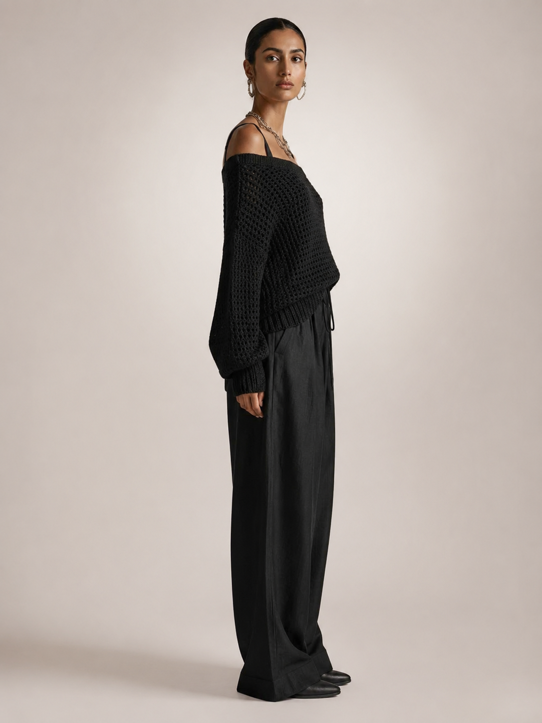 Femme portant un ensemble deux pièces avec haut en maille épaules dénudées et pantalon large, coloris noir