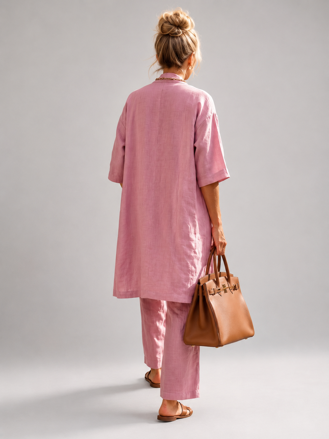 Femme portant un ensemble trois pièces avec haut, pantalon large et pièce ouverte assortie, coloris rose