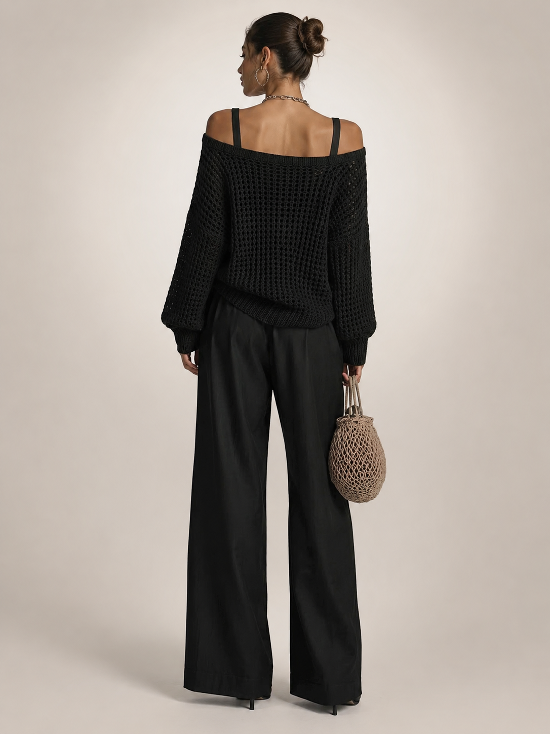 Femme portant un ensemble deux pièces avec haut en maille épaules dénudées et pantalon large, coloris noir