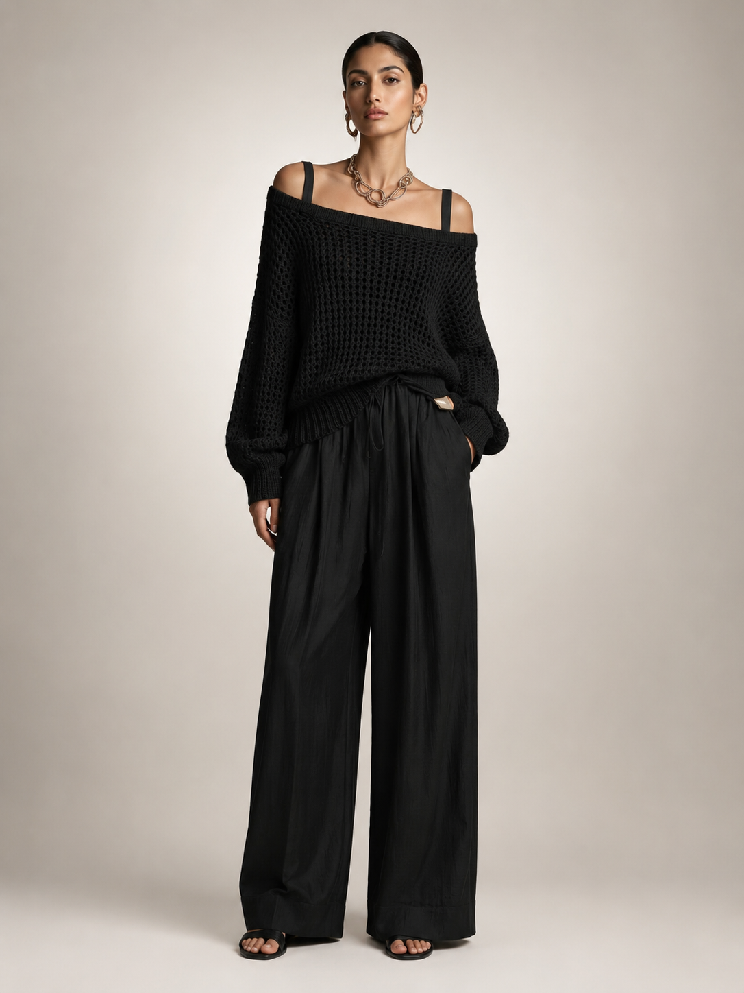 Femme portant un ensemble deux pièces avec haut en maille épaules dénudées et pantalon large, coloris noir