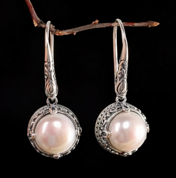 Cadre Voluté | Boucles d'oreilles argentées avec perle blanche dans un cadre ornemental – Vue 01