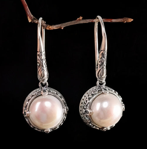 Cadre Voluté | Boucles d'oreilles argentées avec perle blanche dans un cadre ornemental – Vue 01
