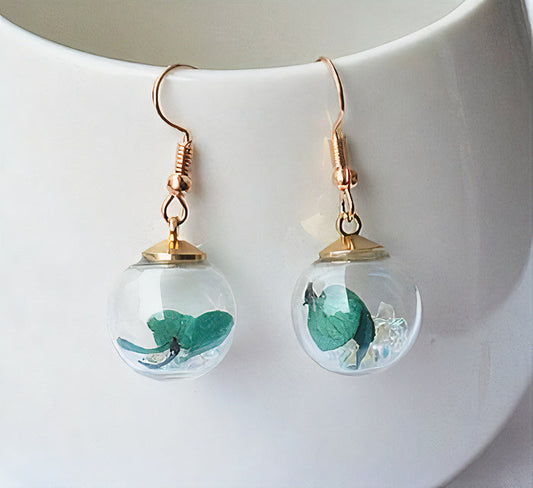 Perle Claire | Boucles d'oreilles avec sphère transparente et feuilles vertes – Vue 01