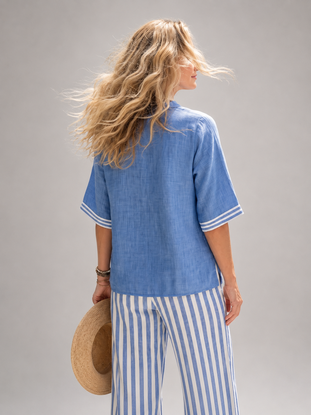 Femme portant un ensemble deux pièces avec tunique col V et pantalon large à rayures, coloris bleu