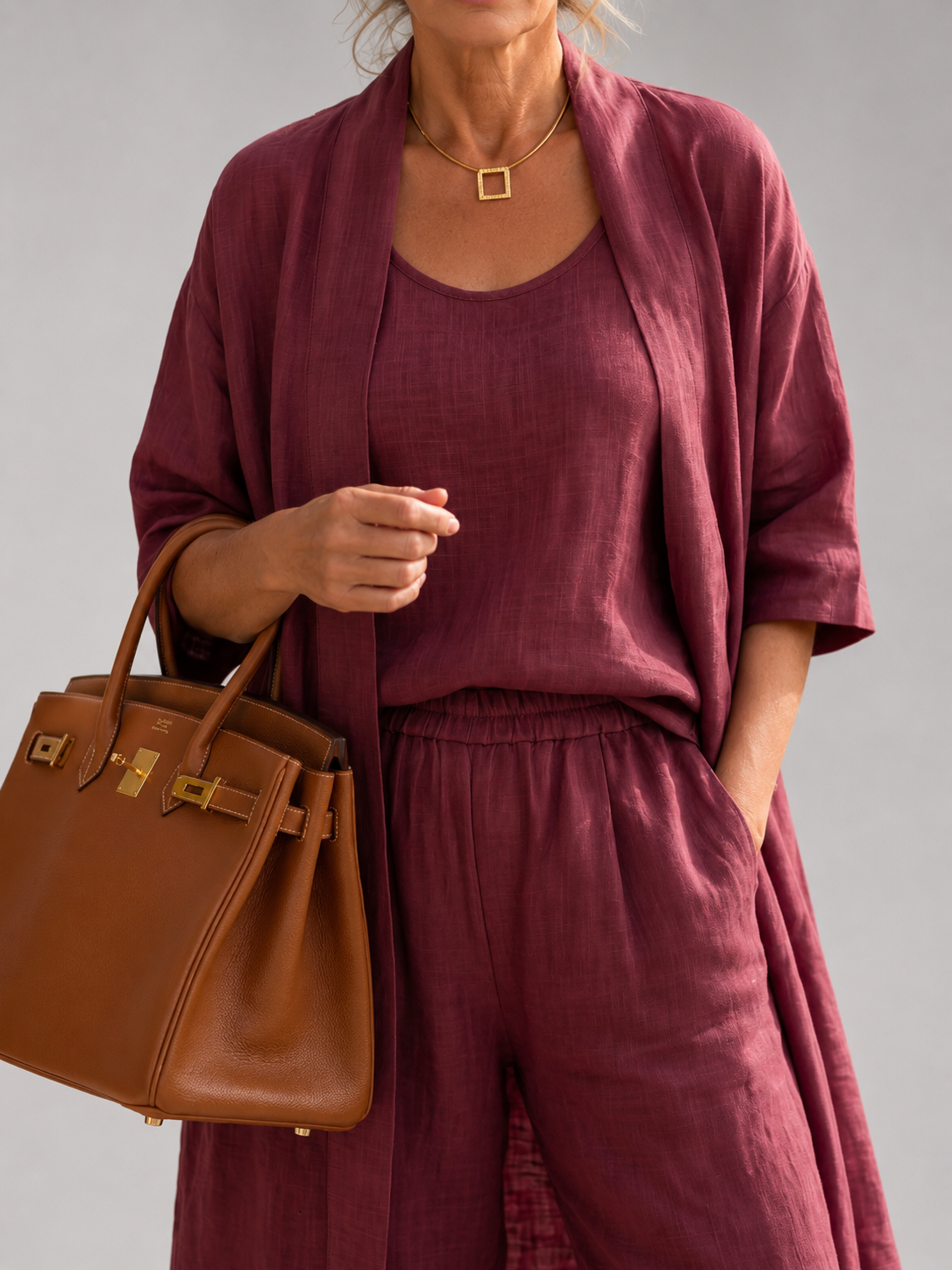Femme portant un ensemble trois pièces avec haut, pantalon large et pièce ouverte assortie, coloris rouge