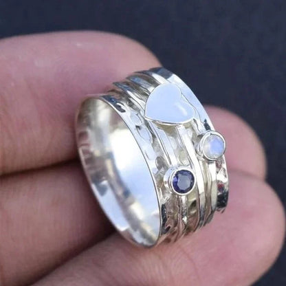 Cœur Pivotant | Bague tournante large argentée avec cœur et pierres bleues – Vue 02