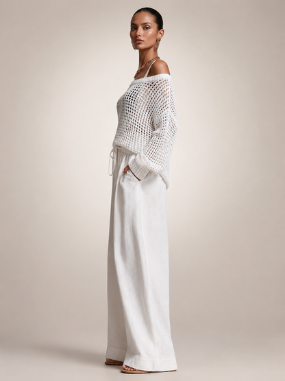 Femme portant un ensemble deux pièces avec haut en maille épaules dénudées et pantalon large, coloris blanc