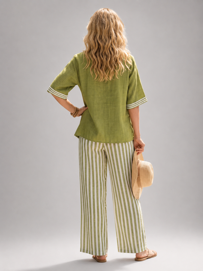 Femme portant un ensemble deux pièces avec tunique col V et pantalon large à rayures, coloris vert