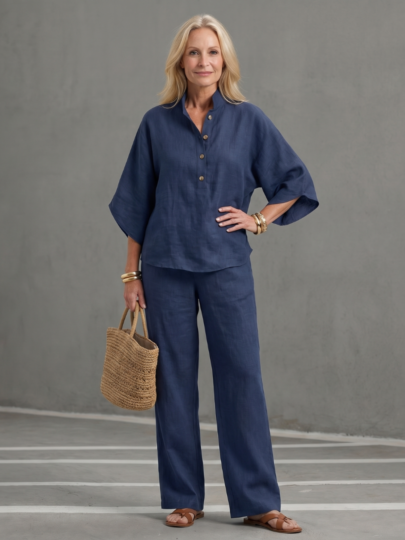 Femme portant un ensemble deux pièces avec tunique boutonnée et pantalon droit, coloris bleu marine