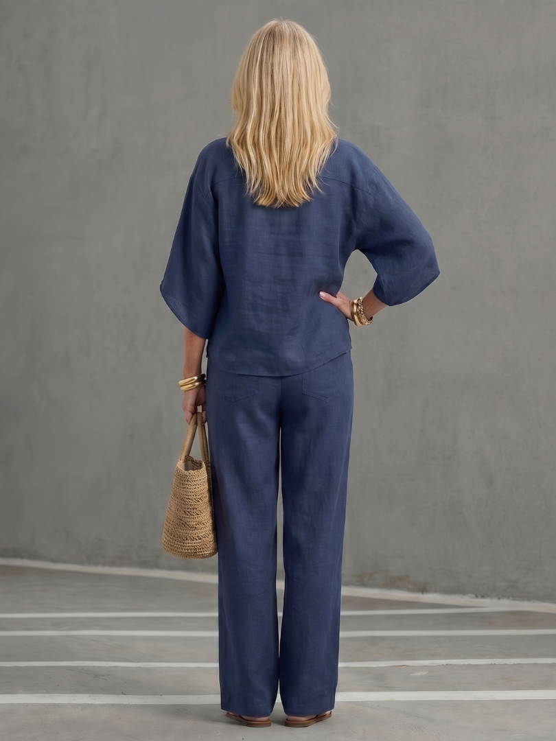 Femme portant un ensemble deux pièces avec tunique boutonnée et pantalon droit, coloris bleu marine