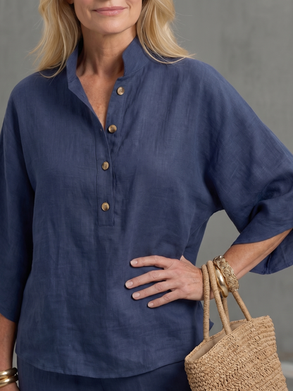 Femme portant un ensemble deux pièces avec tunique boutonnée et pantalon droit, coloris bleu marine