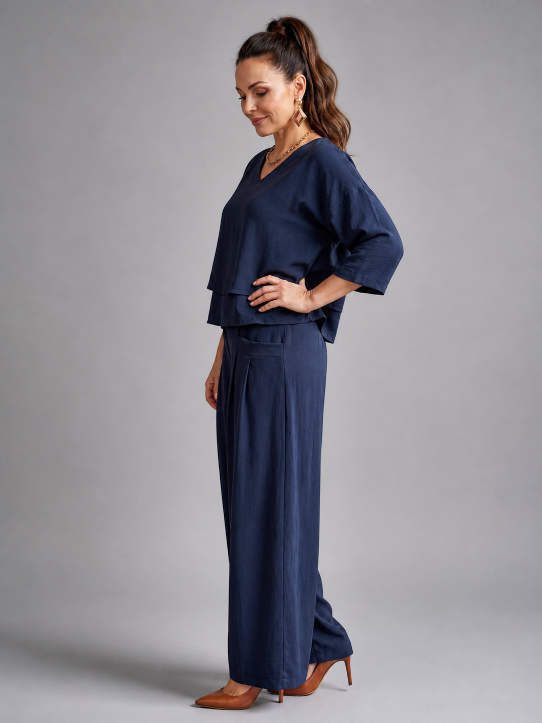 Femme portant un ensemble deux pièces avec haut superposé et pantalon à jambes larges, coloris bleu marine