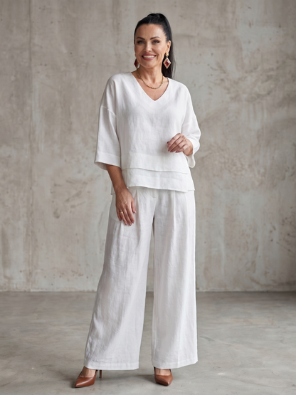 Femme portant un ensemble deux pièces avec haut superposé et pantalon à jambes larges, coloris blanc