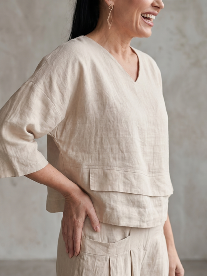 Femme portant un ensemble deux pièces avec haut superposé et pantalon à jambes larges, coloris beige