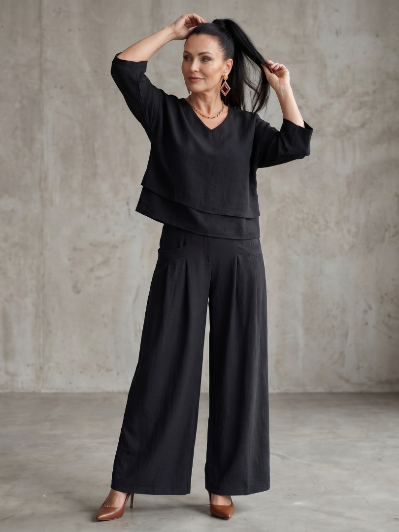 Femme portant un ensemble deux pièces avec haut superposé et pantalon à jambes larges, coloris noir
