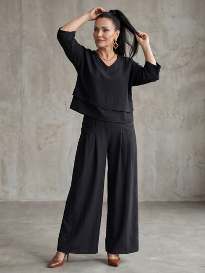 Femme portant un ensemble deux pièces avec haut superposé et pantalon à jambes larges, coloris noir