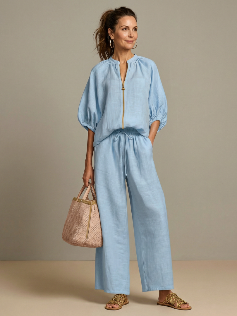 Femme portant un ensemble deux pièces avec blouse zippée et pantalon à jambes larges, coloris bleu
