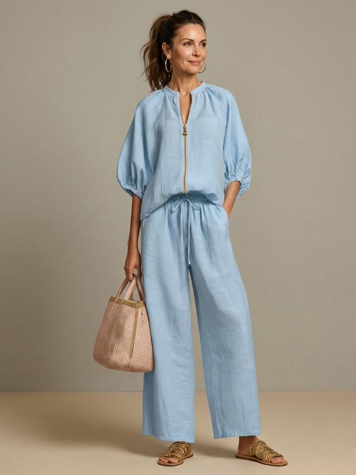 Femme portant un ensemble deux pièces avec blouse zippée et pantalon à jambes larges, coloris bleu