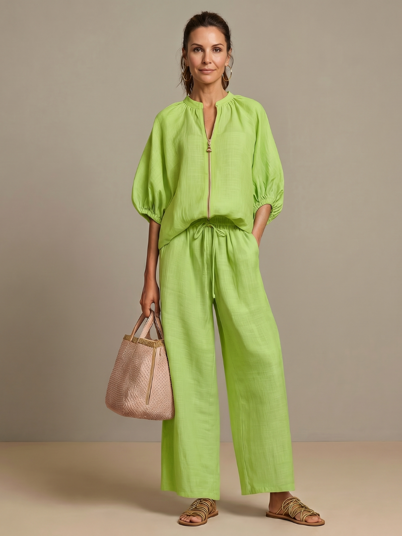 Femme portant un ensemble deux pièces avec blouse zippée et pantalon à jambes larges, coloris vert