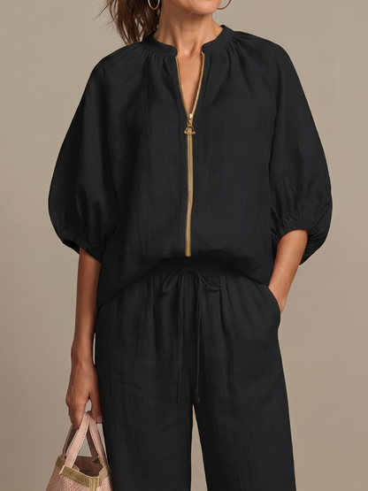 Femme portant un ensemble deux pièces avec blouse zippée et pantalon à jambes larges, coloris noir