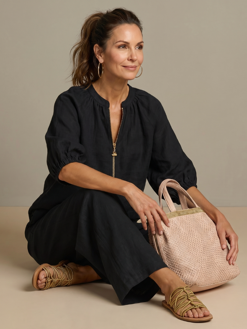 Femme portant un ensemble deux pièces avec blouse zippée et pantalon à jambes larges, coloris noir