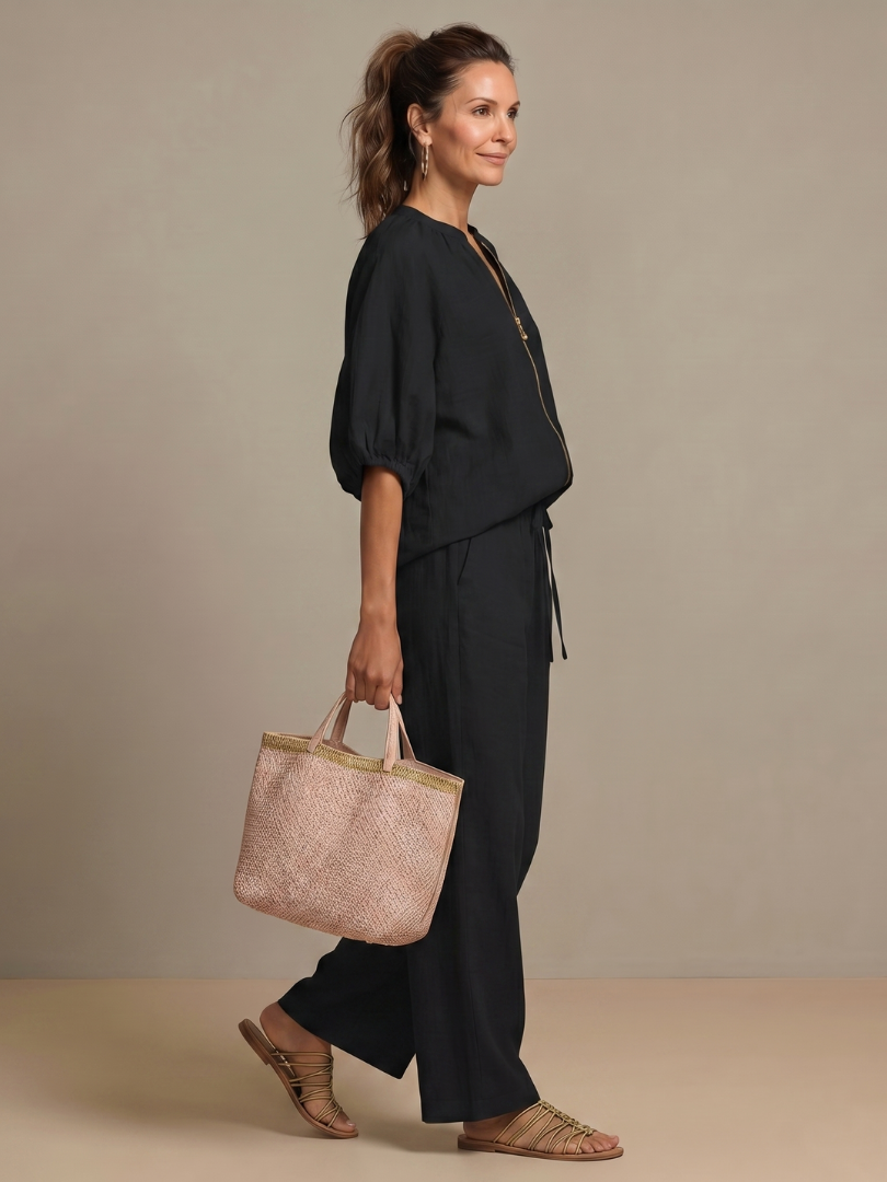 Femme portant un ensemble deux pièces avec blouse zippée et pantalon à jambes larges, coloris noir