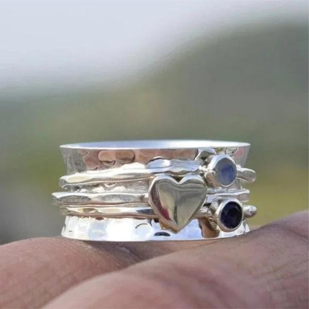 Cœur Pivotant | Bague tournante large argentée avec cœur et pierres bleues – Vue 01