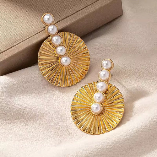 Disque Rayonnant | Boucles d'oreilles dorées à motif rayonnant et perles blanches – Vue 01