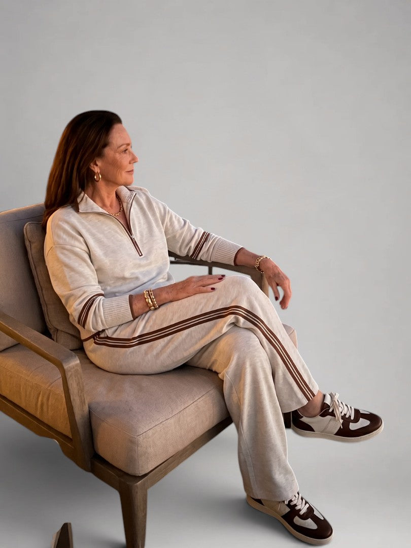 Femme portant un ensemble deux pièces en maille avec haut à col zippé et pantalon large, coloris blanc