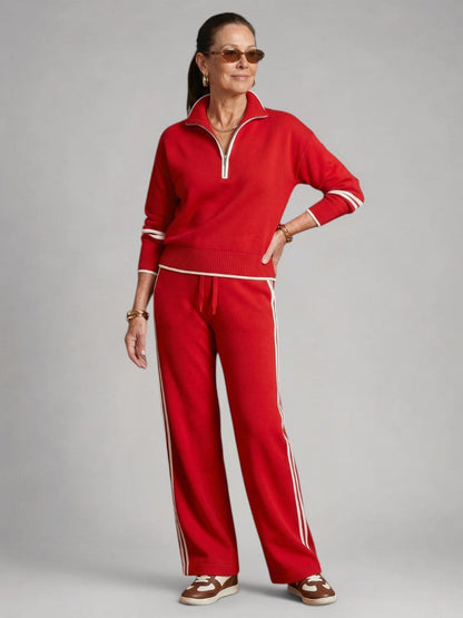 Femme portant un ensemble deux pièces en maille avec haut à col zippé et pantalon large, coloris rouge