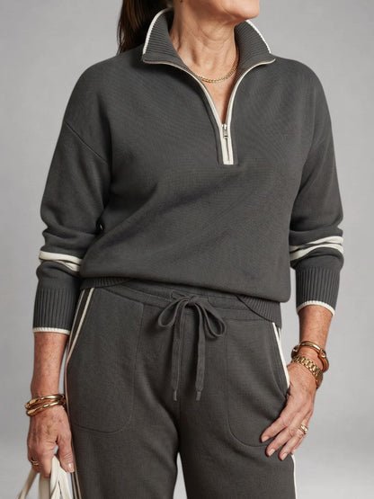 Femme portant un ensemble deux pièces en maille avec haut à col zippé et pantalon large, coloris gris